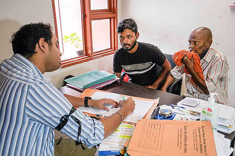 A doctor wearing black strip checks patients in Lucknow